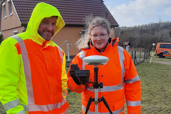 Ausbilder Herr Schulz erklärt Azubi Lena das GNSS Gerät